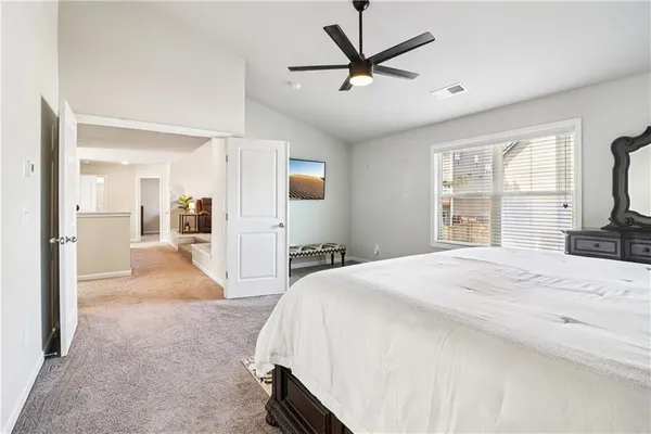 a spacious bedroom with a bed and a large mirror