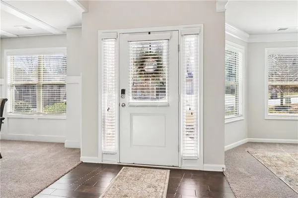 an entryway with wooden floor and windows