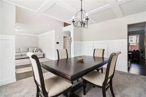 a view of a dining room with furniture and a chandelier