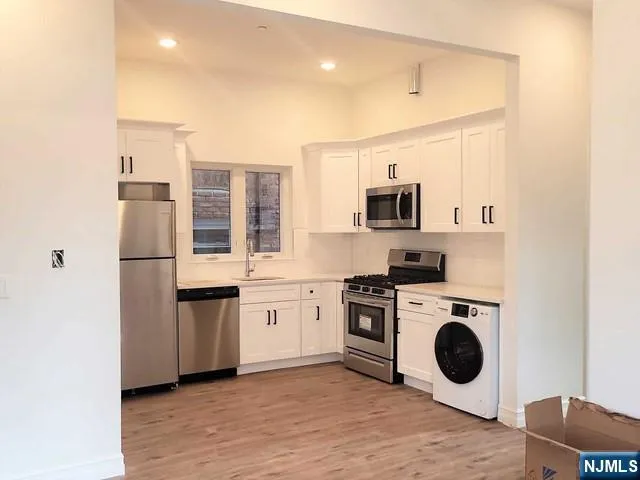 a kitchen with a stove top oven and refrigerator