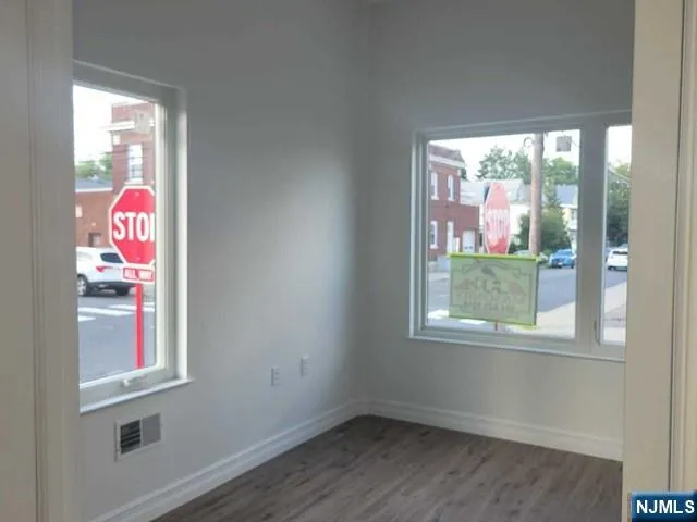 a view of a room that has a window and wooden floor
