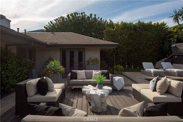 a view of a patio with couches table and chairs and potted plants