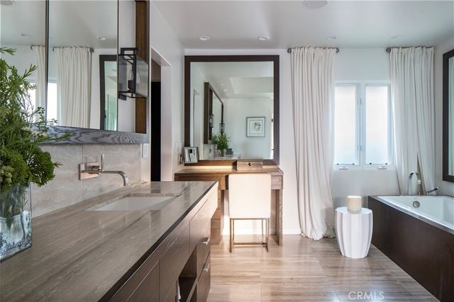a bathroom with a granite countertop sink and a large mirror
