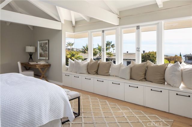 a large white bed sitting in a bedroom next to a window