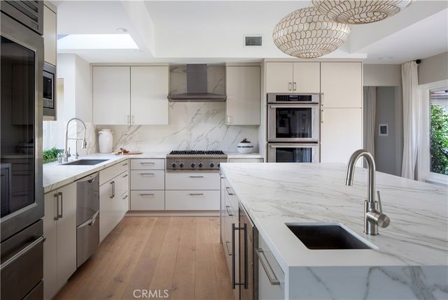 a kitchen with stainless steel appliances a sink a stove and cabinets