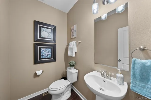 a bathroom with a toilet a sink and mirror