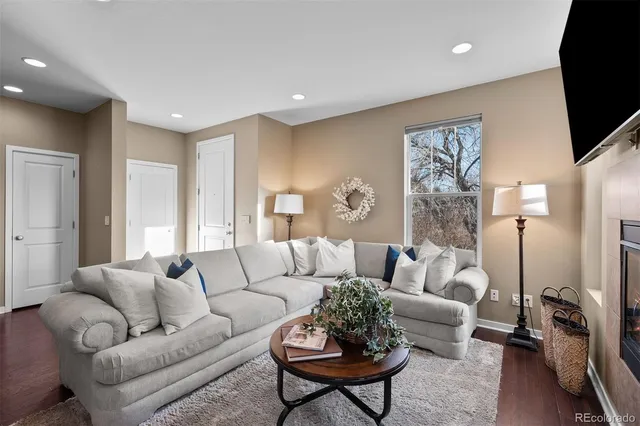 a living room with furniture a flat screen tv and a large window
