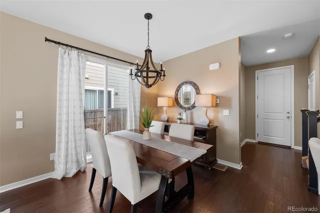 a view of a dining room with furniture a chandelier and wooden floor