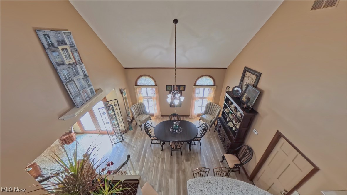 7017 Kirk Road Canfield, OH 44406 - Photo 15 of 35 Dining room featuring wood finished floors, a chandelier, and high vaulted ceiling