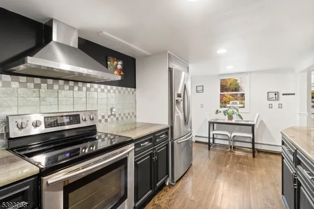 a kitchen with a stove and a wooden floor