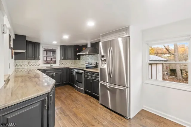 a kitchen with a refrigerator a sink and a stove top oven