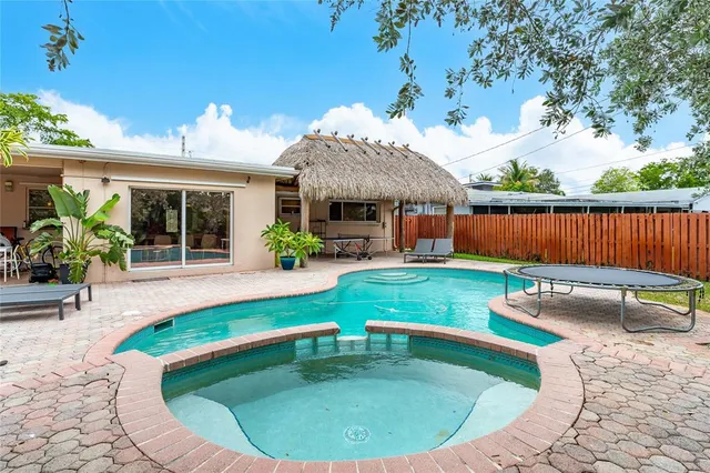 a view of a house with swimming pool next to a yard