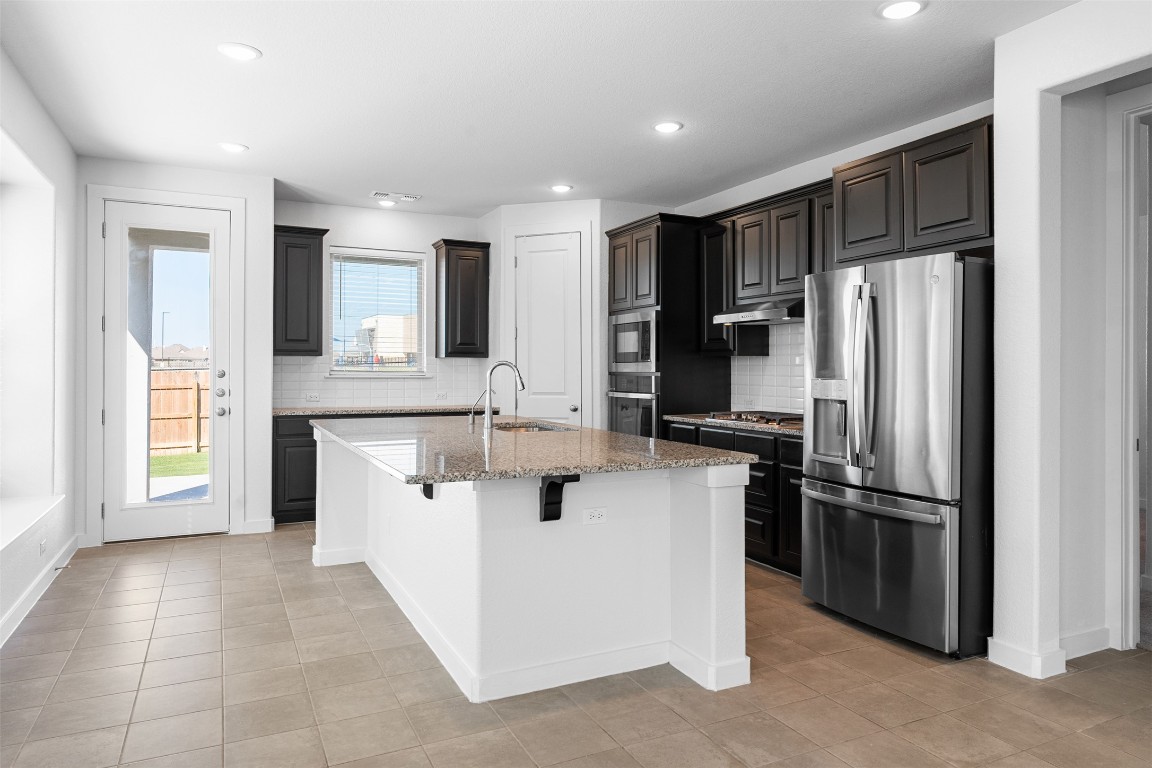121 Rangel Drive Liberty Hill, TX 78642 - Photo 7 of 23 a kitchen with stainless steel appliances granite countertop a refrigerator and a sink