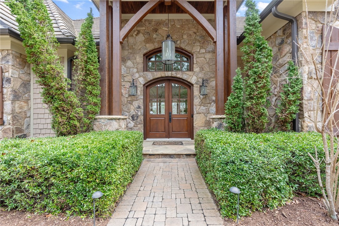 117 Sunrise Ridge Sunset, SC 29685 - Photo 2 of 37 This grand entrance features natural stone, rich wood details, and lush landscaping.