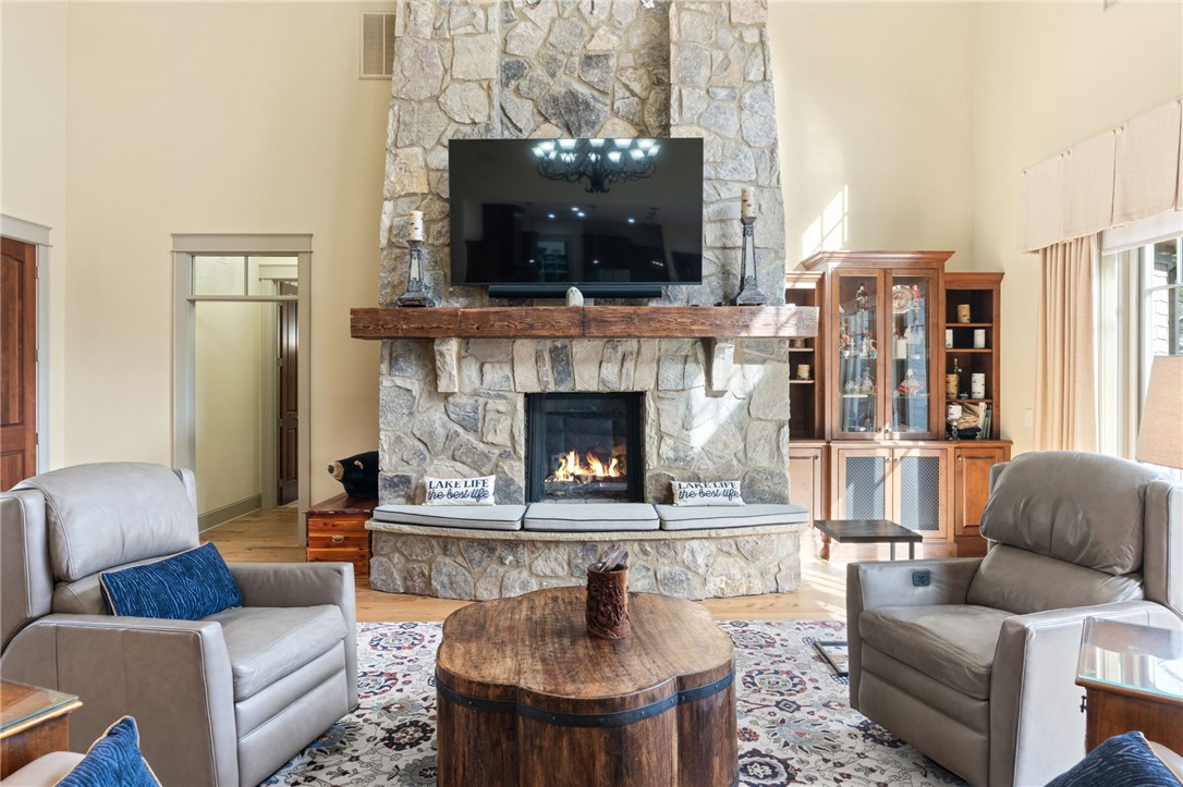 117 Sunrise Ridge Sunset, SC 29685 - Photo 7 of 37 This living area features a grand stone fireplace with a substantial wood mantel, offering warmth and comfort.