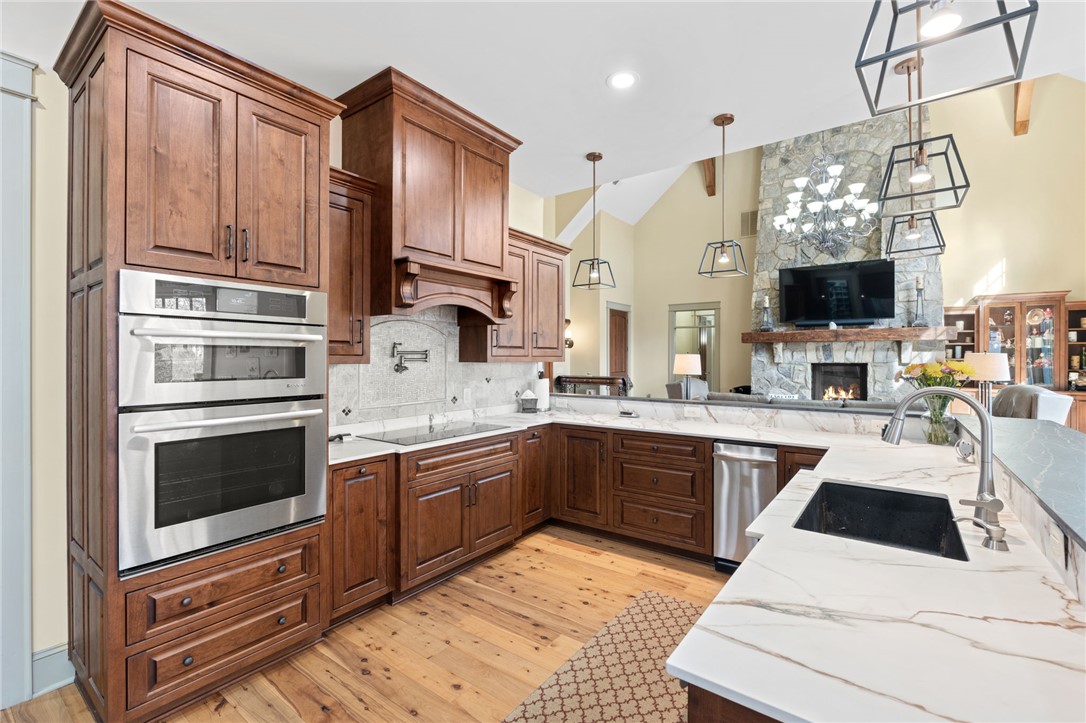 117 Sunrise Ridge Sunset, SC 29685 - Photo 9 of 37 This kitchen features rich wood cabinetry, elegant marble countertops, and warm hardwood flooring.