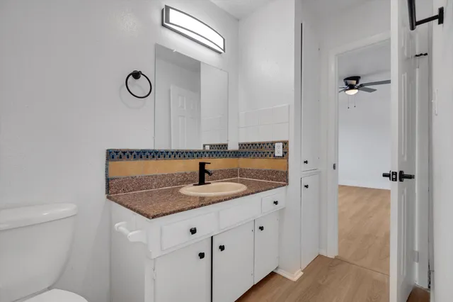 a bathroom with a granite countertop sink and a mirror