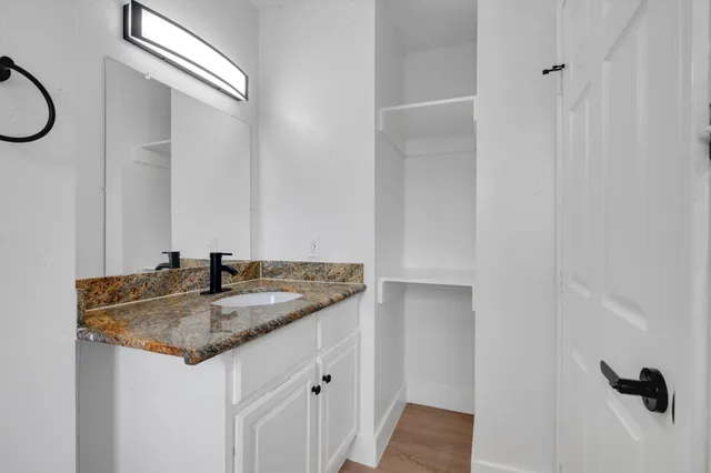 a bathroom with a granite countertop sink and a mirror