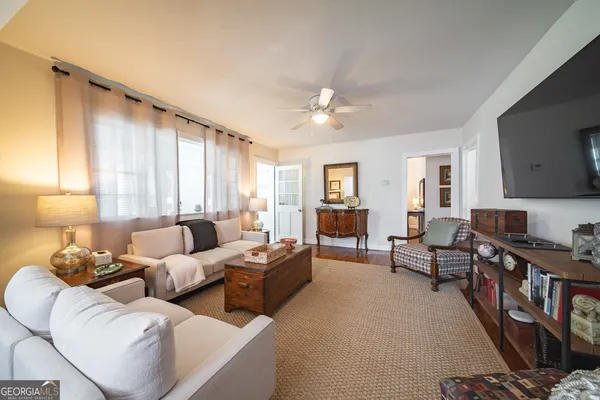 a living room with furniture ceiling fan and a window