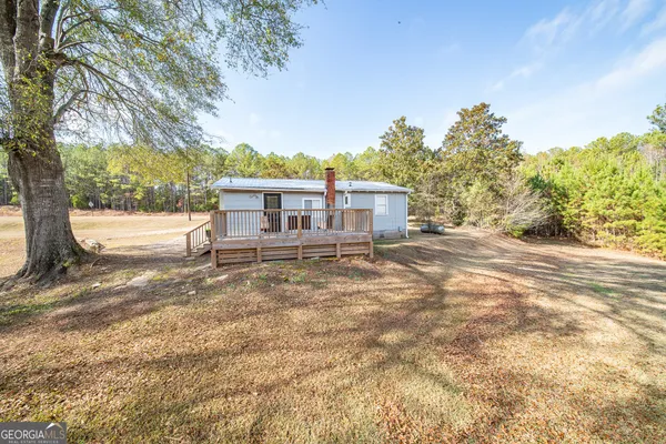 a kitchen with granite countertop a refrigerator a sink dishwasher a stove and white cabinets with wooden floor
