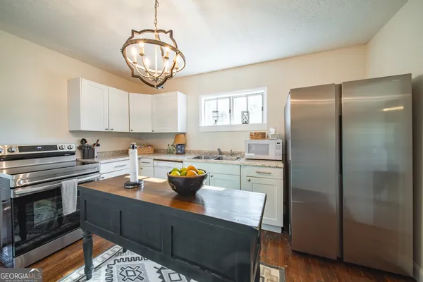 a kitchen with a refrigerator and a stove top oven