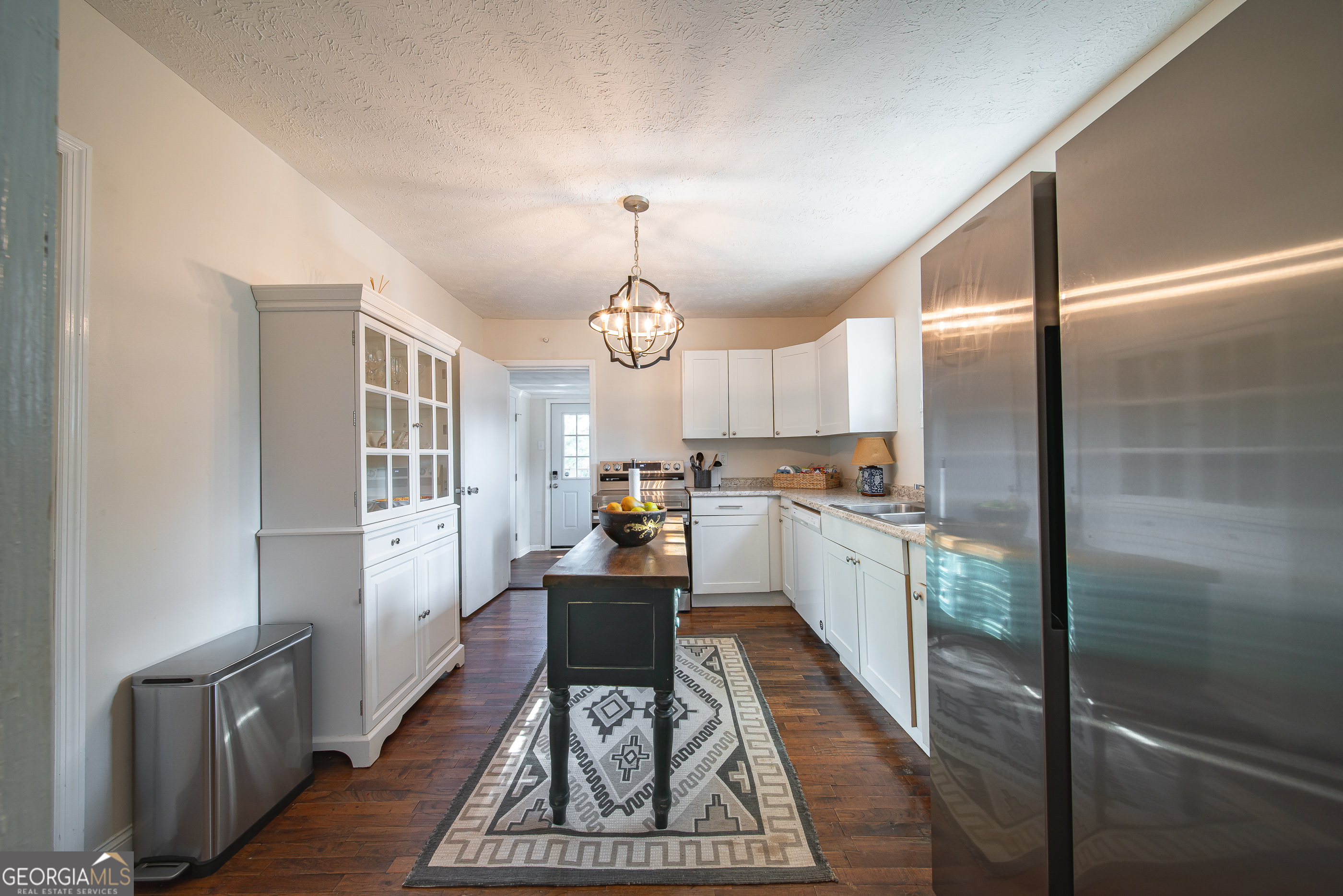 161 Calhoun Road Hamilton, GA 31811 - Photo 25 of 90 a kitchen with granite countertop a refrigerator a sink dishwasher a stove and white cabinets with wooden floor