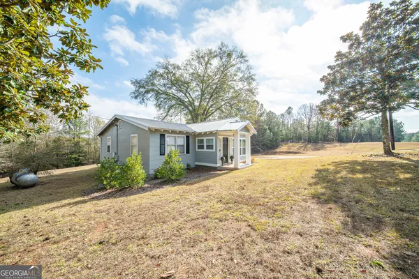 a view of a house with backyard and wooden fence