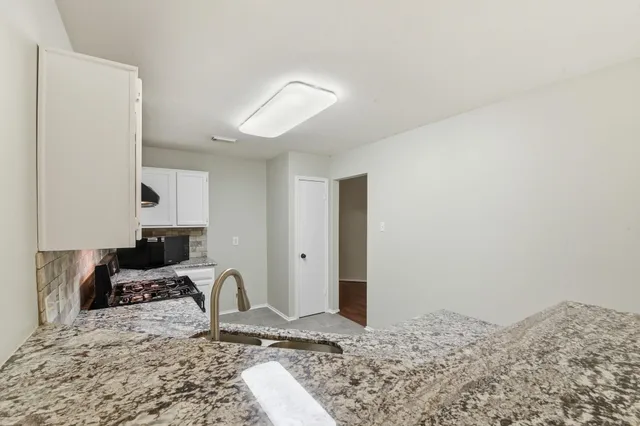 a kitchen with a stove sink and cabinets