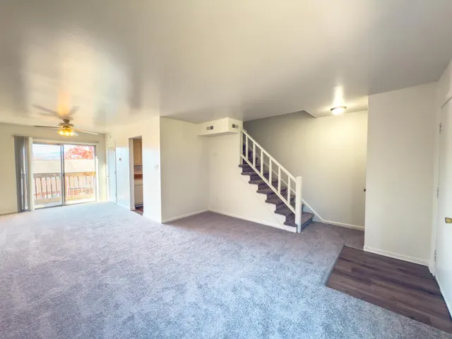 a view of an empty room with stairs and a window