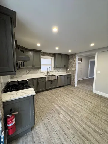 a large kitchen with stainless steel appliances granite countertop a stove a sink and a refrigerator