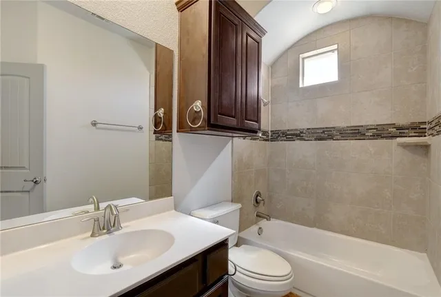 a bathroom with a toilet sink vanity and mirror