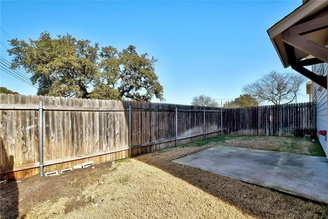 a view of a house with a small yard and wooden fence