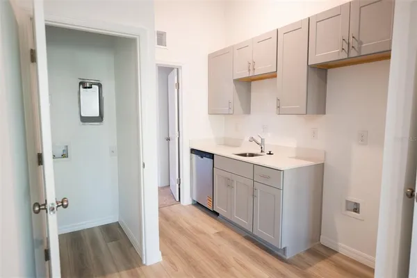 a large white kitchen with stainless steel appliances a sink and a refrigerator