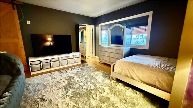 a bedroom with a bed and a flat screen tv