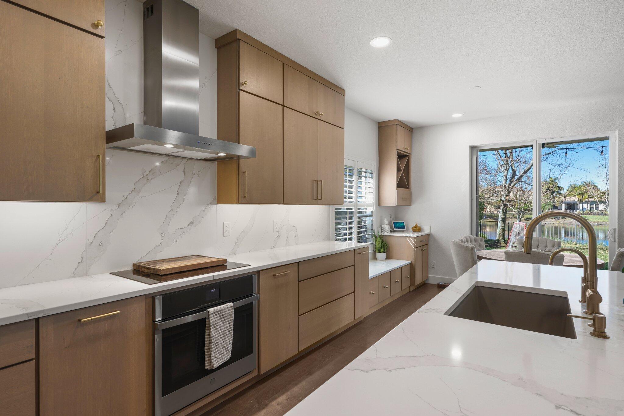168 Andros Harbour Place Jupiter, FL 33458 - Photo 25 of 71 a kitchen with stainless steel appliances a sink a stove and cabinets
