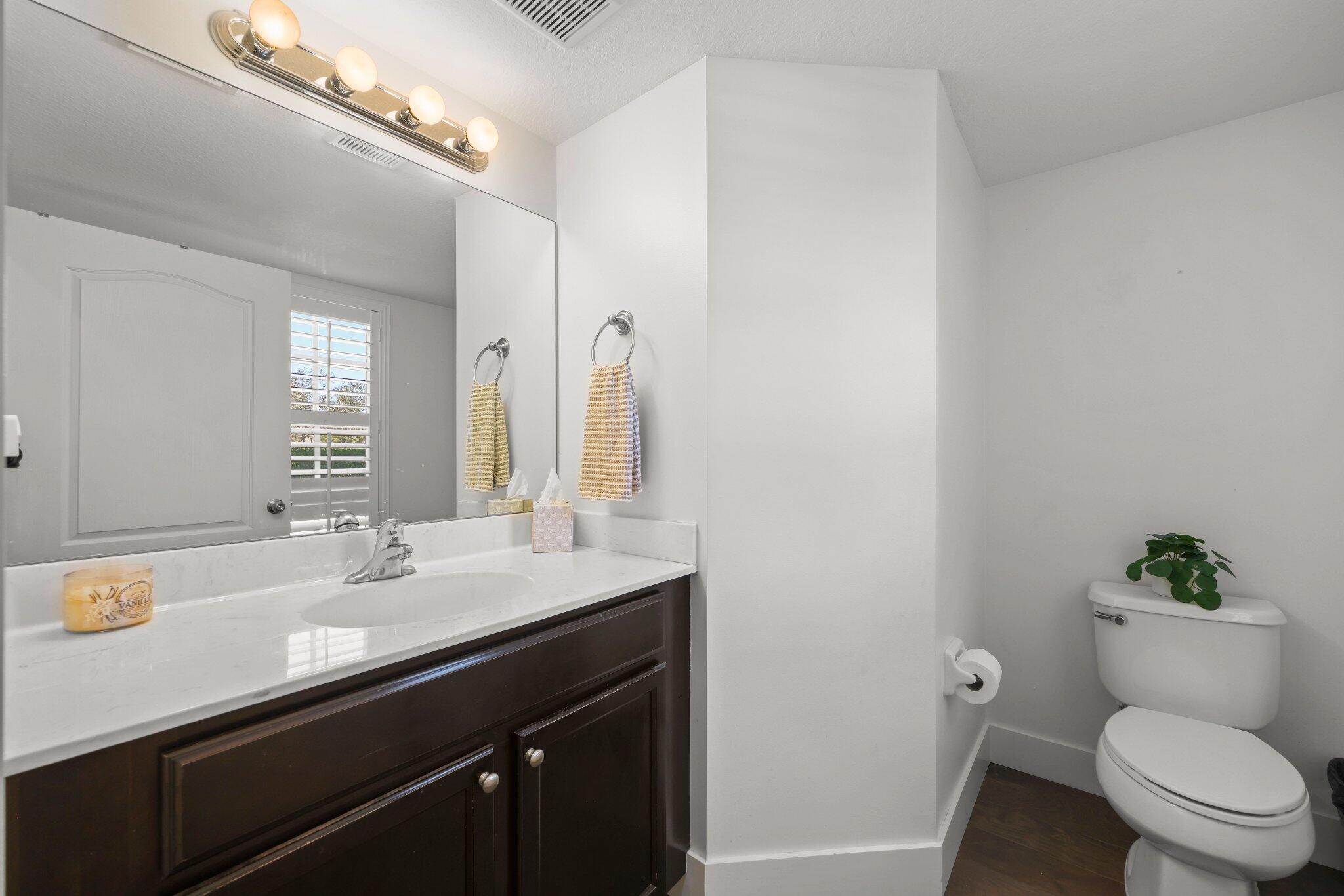 168 Andros Harbour Place Jupiter, FL 33458 - Photo 29 of 71 a bathroom with a sink a toilet a mirror and vanity