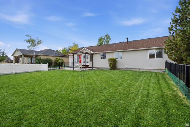 791 East Saddle Road Grantsville, UT 84029 - Photo 39 of 46 Expansive backyard featuring a manicured lawn, a concrete patio, and a pergola