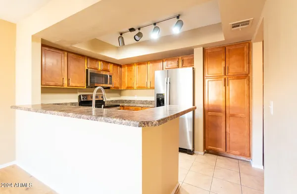 a kitchen with stainless steel appliances granite countertop a sink and a refrigerator