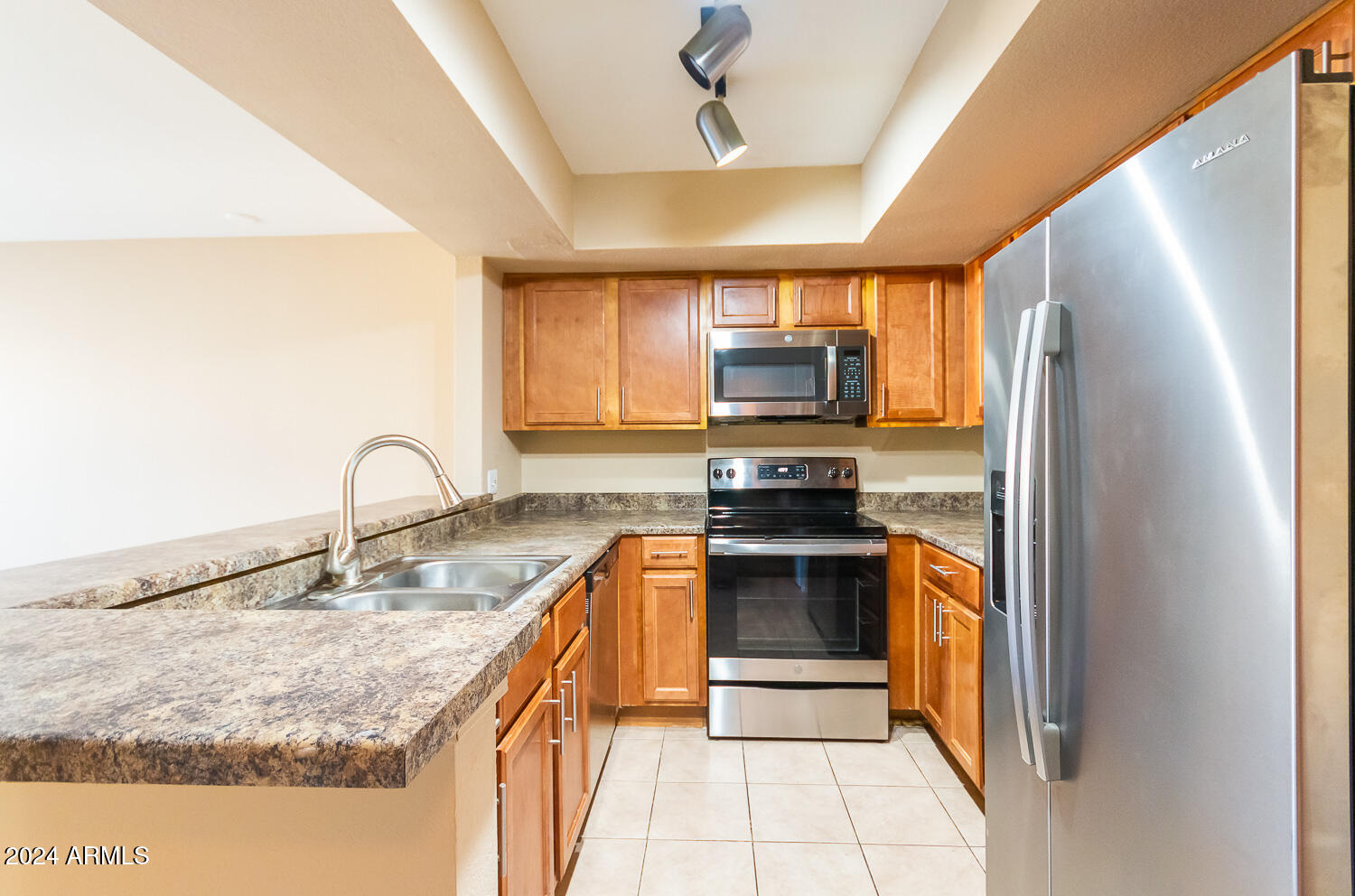 1331 West Baseline Road, Unit 253 Mesa, AZ 85202 - Photo 14 of 31 a kitchen with kitchen island granite countertop a sink stainless steel appliances and cabinets
