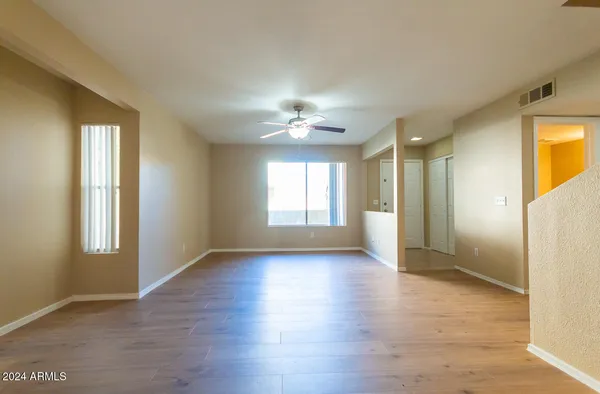 a view of n empty room with window and wooden floor