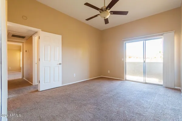 an empty room with a ceiling fan and a window
