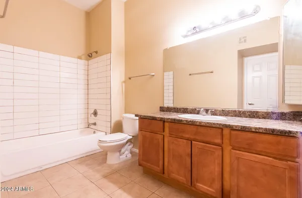 a bathroom with a granite countertop sink a toilet and mirror
