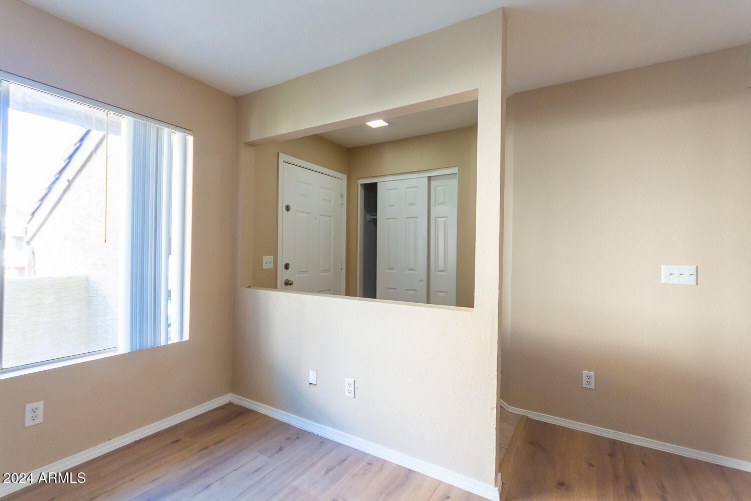 1331 West Baseline Road, Unit 253 Mesa, AZ 85202 - Photo 5 of 31 a view of an empty room with wooden floor and a window