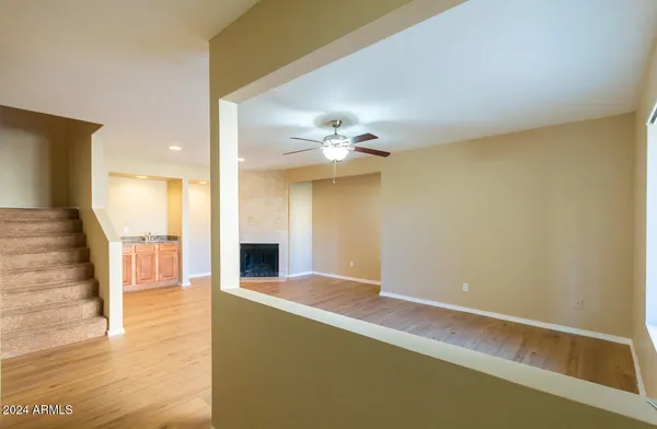 a view of a livingroom with a ceiling fan and wooden floor