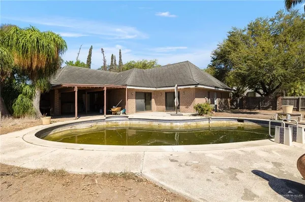 a swimming pool with outdoor seating and barbeque oven
