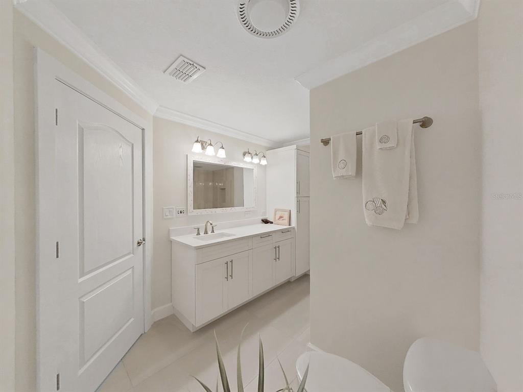 825 East Gulf Boulevard, Unit 110 Indian Rocks Beach, FL 33785 - Photo 27 of 75 a bathroom with a granite countertop sink a toilet and shower