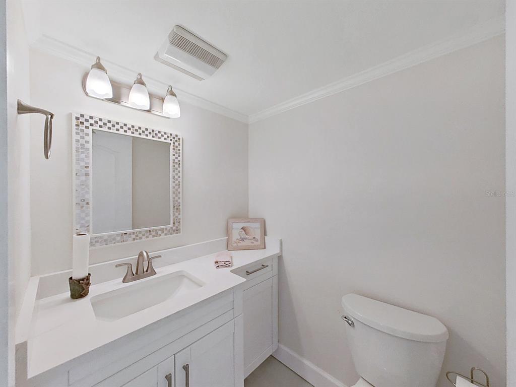825 East Gulf Boulevard, Unit 110 Indian Rocks Beach, FL 33785 - Photo 30 of 75 a bathroom with a toilet a sink a mirror and vanity