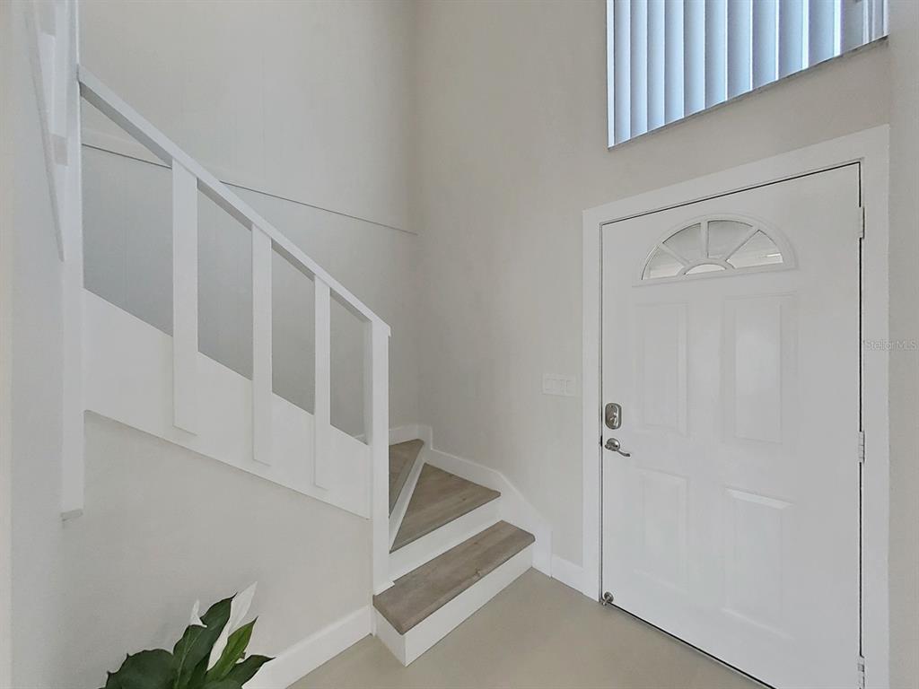 825 East Gulf Boulevard, Unit 110 Indian Rocks Beach, FL 33785 - Photo 32 of 75 a view of staircase with white walls and a window