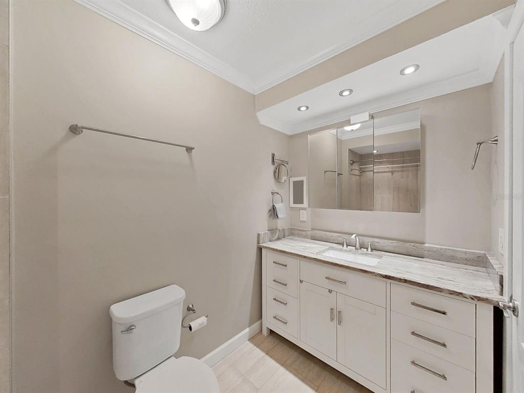 825 East Gulf Boulevard, Unit 110 Indian Rocks Beach, FL 33785 - Photo 37 of 75 a bathroom with a granite countertop sink mirror and toilet