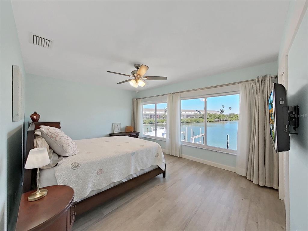 825 East Gulf Boulevard, Unit 110 Indian Rocks Beach, FL 33785 - Photo 40 of 75 a bedroom with a bed and wooden floor